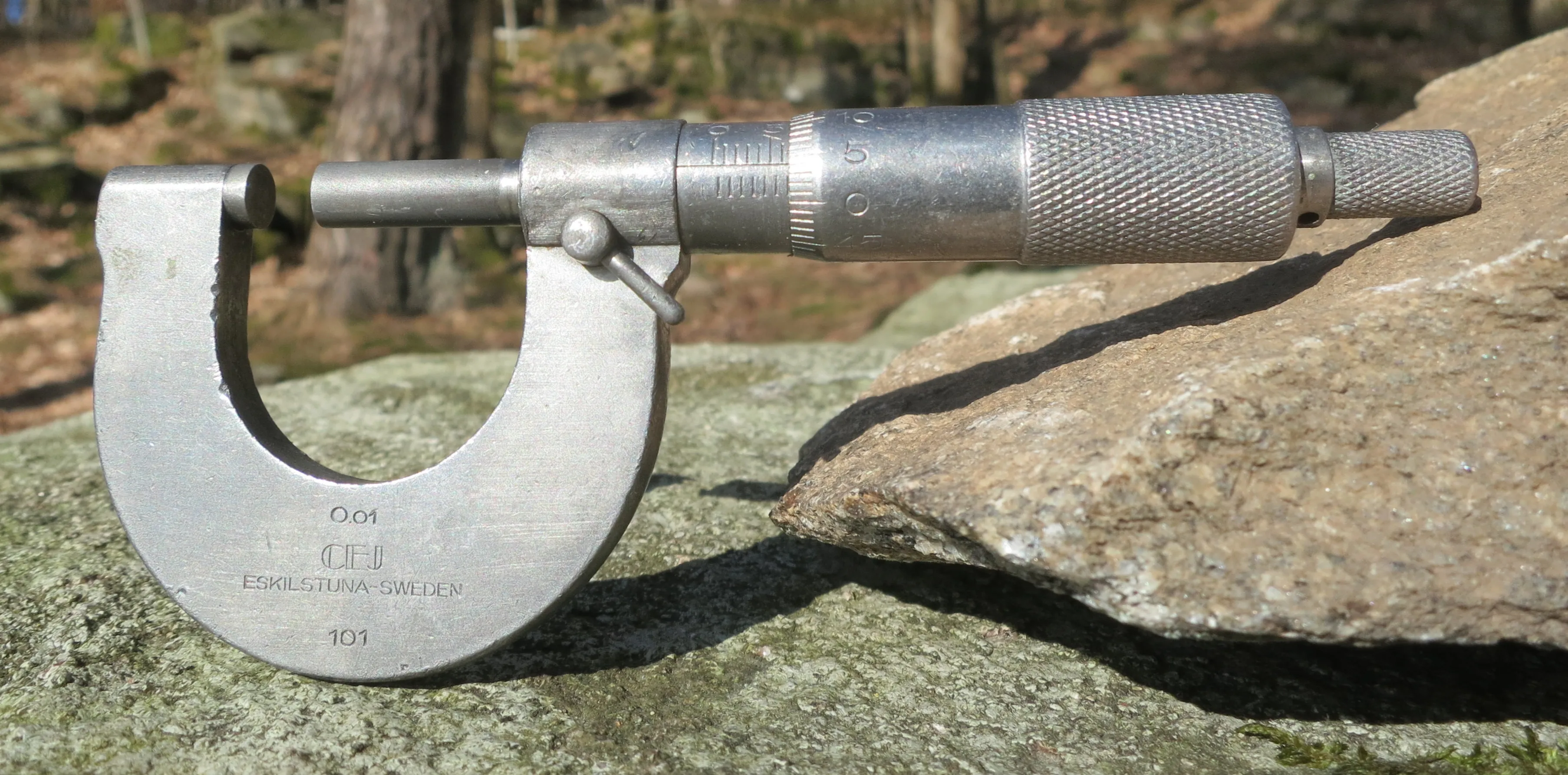 A mid-twentieth-century outside micrometer reading to 0.01 mm — a precision measuring instrument.